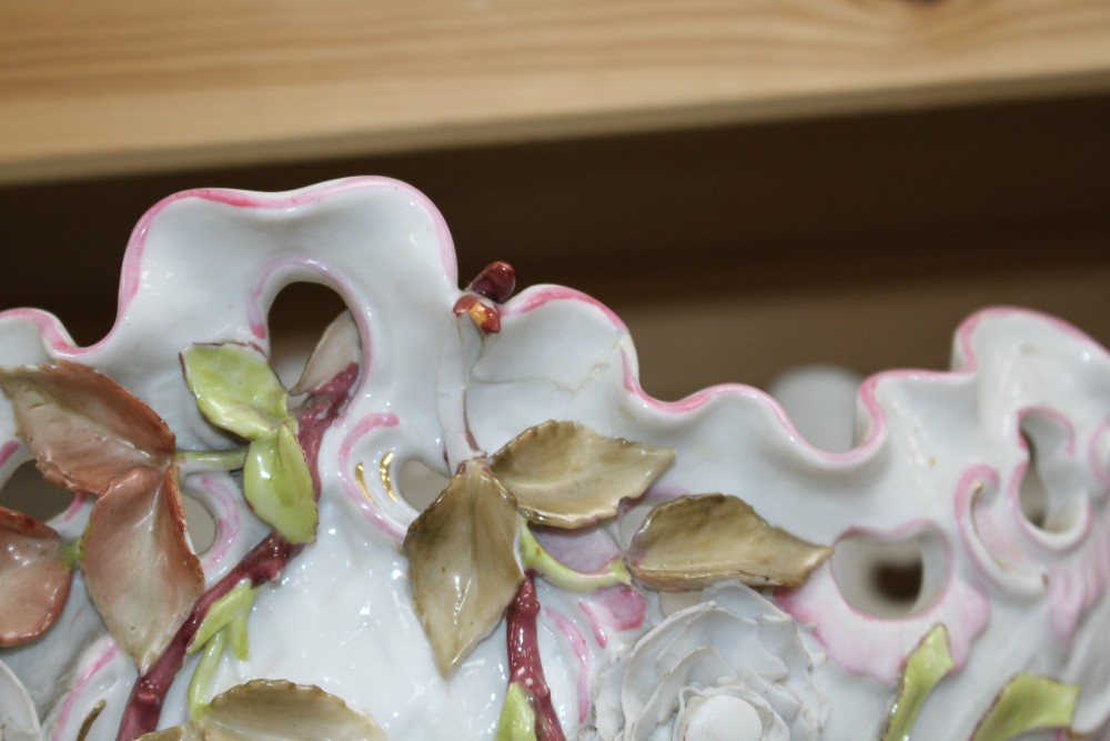 An early 20th century German porcelain centrepiece, with floral encrusted bowl supported by three children, height 28.5cm, width 44cm